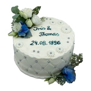 Hochzeitstorte weiß mit Blumen und Perlenverzierung am Rand